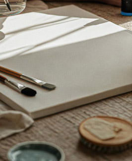 Blank canvas with brushes and studio supplies