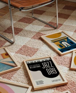 Framed art prints on carpet next to a chair