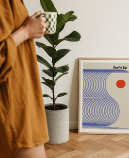 Framed surf poster next to a plant