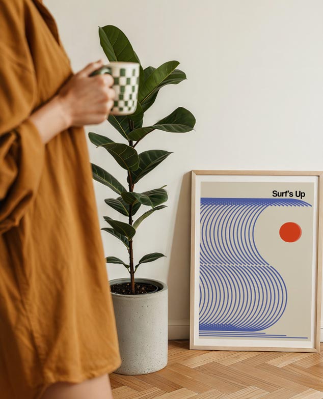 Framed surf poster next to a plant