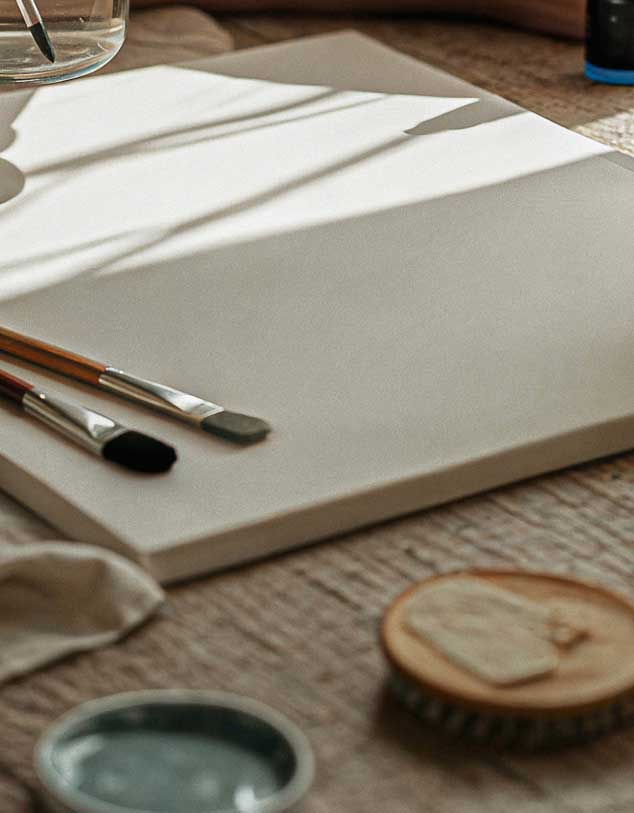 Blank canvas with brushes and studio supplies